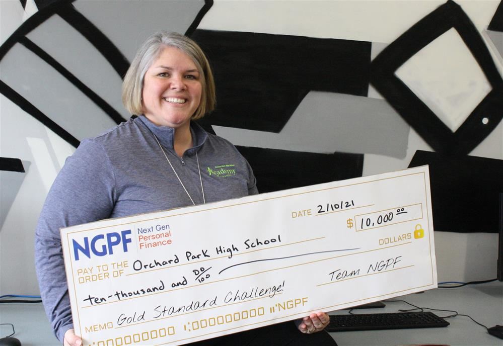 Business teacher, Kristen Casto smiles while holding the oversized grant check in her classroom.. Business teacher, Kristen Casto smiles while holding the oversized grant check in her classroom..