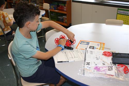 Male student building a sail car at a table