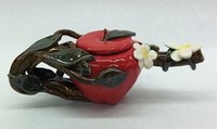ceramic apple with branch and leaves wrapped around it