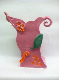 pink ceramic decorative piece with flowers and leaf